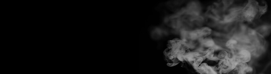 White smoke on a black background. Texture of smoke. Clubs of white smoke on a dark background for an overlay