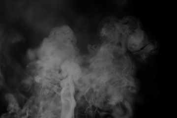 White smoke on a black background. Texture of smoke. Clubs of white smoke on a dark background for an overlay