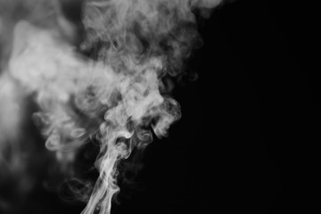 White smoke on a black background. Texture of smoke. Clubs of white smoke on a dark background for an overlay