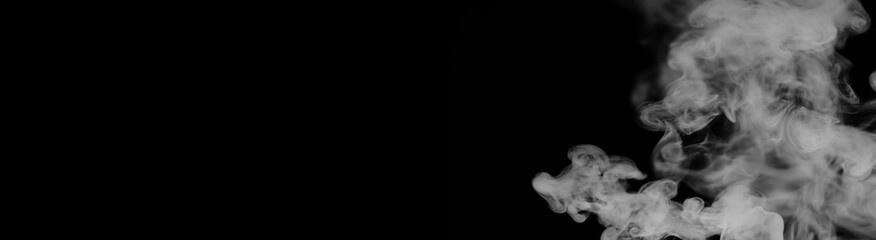 White smoke on a black background. Texture of smoke. Clubs of white smoke on a dark background for an overlay