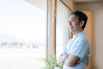 窓の外を見る医師（笑顔）
