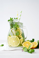 Fototapeta Lemonade in glass jug on light background. Lemon, Mint and Ice Ingredients obraz