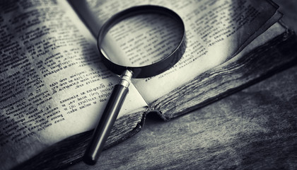 An old retro book on the table. An encyclopedia of the past on an old wooden countertop. An old...
