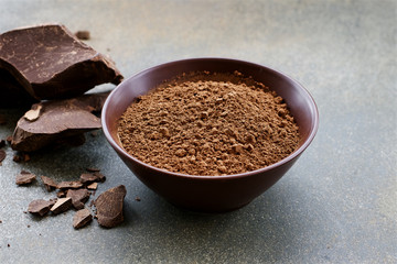 Organic carob powder in a bowl. Natural cocoa substitute. Close up view