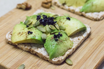 Useful sandwich with avocado, pumpkin seeds and black sesame seeds. Healthy lifestyle.