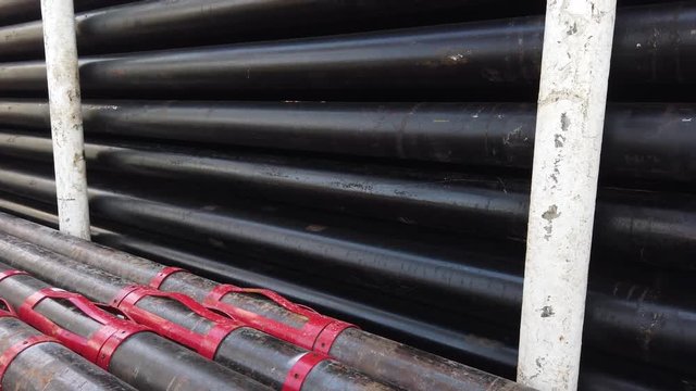 Oil well casing bundles with centralizers installed stacked on the deck of a drilling rig