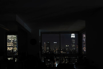 View of night skyscrapers of  New York City (Manhattan) through windows of apartment. Top view of...