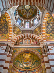 Fototapeta na wymiar Notre-Dame de la Garde is a Catholic basilica in Marseille, France. The basilica consists of a lower church in the Romanesque style, and an upper church of Neo-Byzantine style decorated with mosaics.