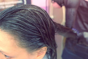 Fototapeta premium Application of keratin to the hair with a brush. Strengthening the hair with keratin.