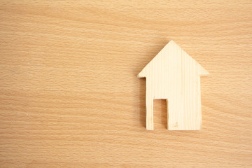 Wood house model with copy space on wood background,Choosing the right real estate property, or new home in a housing development or community.