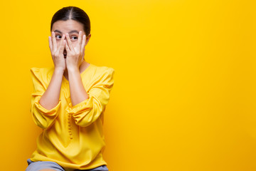 Woman feel scared standing isolated over yellow background