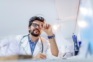 Young attractive male scientist holding a  pill