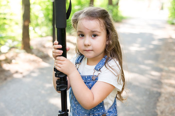 Hobby, profession, children and photographer concept - child with camera in forest