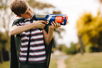 Boy playing super hero boy with gun