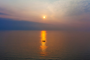 Fototapeta premium Lonely boat in the sea at sunset time