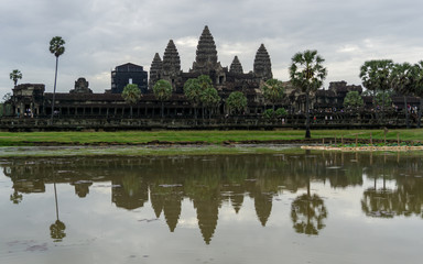 Fototapeta na wymiar Tourists outside the Angkor Wat on a cloudy morning