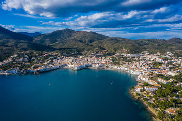 Naklejka na ściany i meble Aerial panoramic view of city Cadaques, sea and mountains, Beautiful Spanish small city by the sea. Drone photo of cityscape