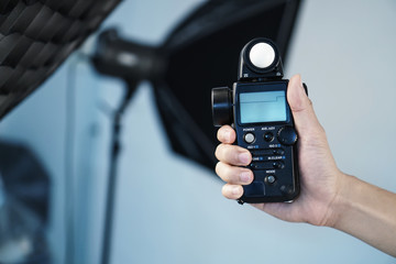 Hand held light meter isolated in studio lights