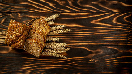 healthy whole grain bread with goji berry and seeds bread. Sliced rye bread on a wooden background with wheat. healthy food concept. space for text. top view
