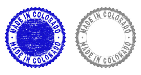Grunge MADE IN COLORADO stamp seals isolated on a white background. Rosette seals with distress texture in blue and grey colors.