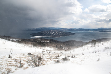 Obraz premium 冬の地吹雪の美幌峠から見た冬の屈斜路湖 （北海道・弟子屈町）