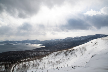 Fototapeta na wymiar 冬の地吹雪の美幌峠から見た冬の屈斜路湖　（北海道・弟子屈町）