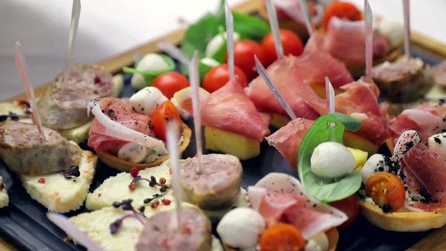Close up buffet table. Sandwiches with sausage, tomato and mozzarella. Delicious snacks on the Banquet table