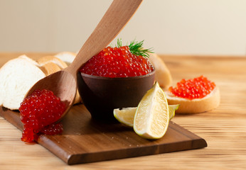 red caviar in a ceramic dish on a wooden background in a rustic style with space for text