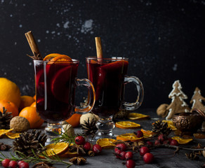 milled Hot wine with Christmas decorations background. Holiday dark photo.