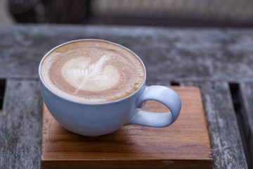 Close-up Of Coffee cup latte art on wooden table.