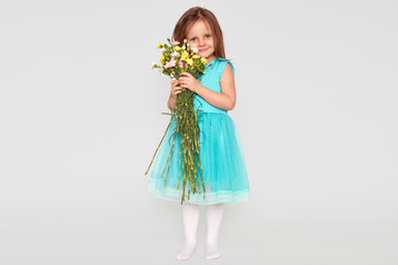 Isolated shot of pretty little girl has appealing appearance, dresed in stylish blue dress and...