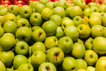 Green apples on a display in a supermarket in bulk