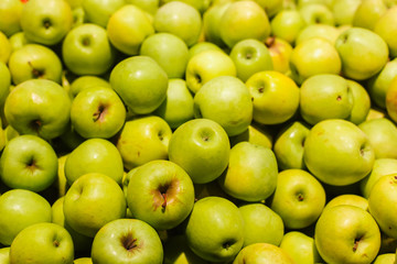 Green apples on a display in a supermarket in bulk