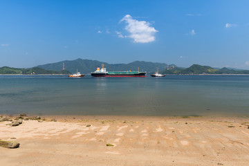 Tanker is pulled out of the harbor. Will be accompanied by two tugs boats.