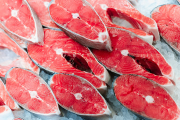 Trout or salmon sliced ​​into pieces for steak lies in a frozen fridge of a display case in a supermarket