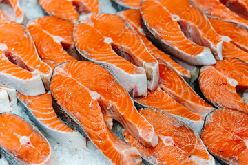 Trout or salmon sliced ​​into pieces for steak lies in a frozen fridge of a display case in a supermarket