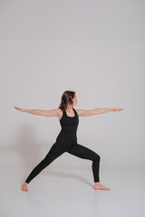 Fototapeta na wymiar Woman practicing and stretching in a yoga studio. Basic yoga pose.