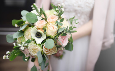 Bride holding stylish wedding flowers bouquet