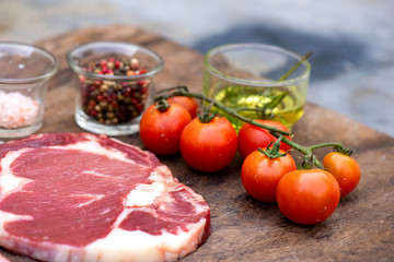 Raw steak with spices and ingredients for cooking