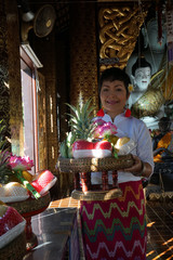 Femme thaïlandaise et offrandes de fruits