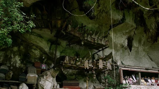 Famous funeral of Tana Toraja.Typical Toraja tombs in a vertical rock wall carved with traditional puppets in memory of the dead, Toraja Land, Sulawesi, Indonesia