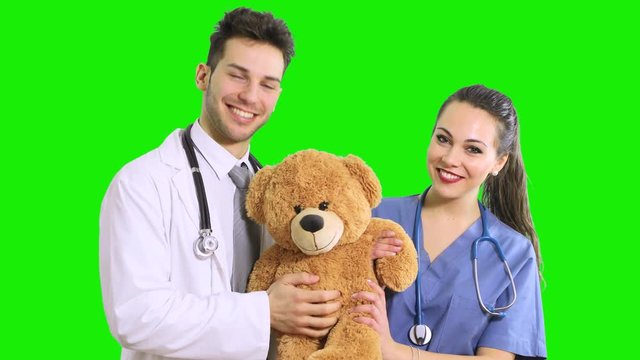 Doctors holding a teddy bear, pediatrician concept, green screen chroma key