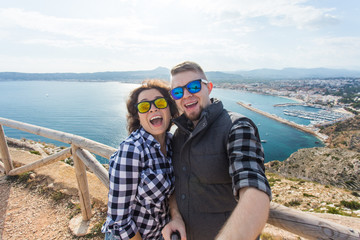 Travel, vacation and holiday concept - Beautiful couple having fun, taking selfie over beautiful landscape