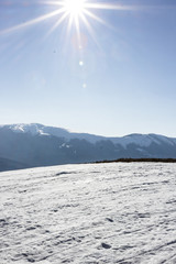 Snow-capped mountains and hills. Mountains Carpathians in Ukraine. Winter mountain landscape. Mountain Bukovel. Panorama from the top of the mountain. Freeride ski slope. Skiing and snowboarding.