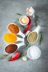 Spices in Wooden spoon. Herbs. Curry, Saffron, turmeric, rosemary, cinnamon, garlic, pepper, anise on wooden rustic background. Collection of spices and herbs. Salt, paprika. Copy space. Top view. Ban