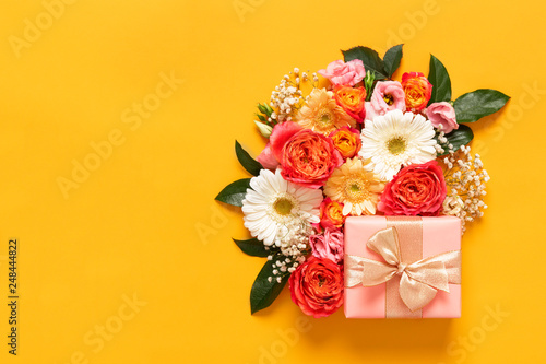 Happy Mother's Day, Women's Day, Valentine's Day or Birthday Pastel Candy Colors Background. Floral flat lay greeting card with beautifuly wrapped present and copy space.