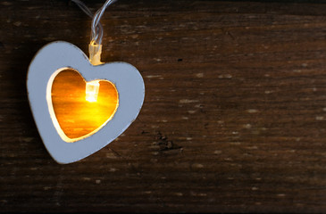 Love valentine's day with hearts garland lights on old wooden background