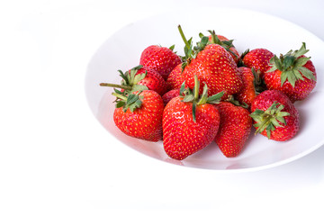 Strawberry fruits on white dish isolated on white background.