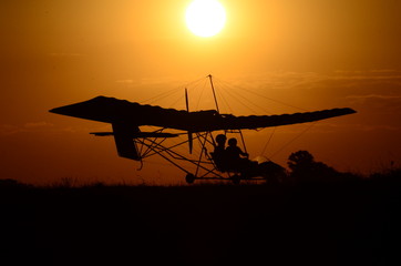 Fototapeta na wymiar Ultralight airplane at sunset.