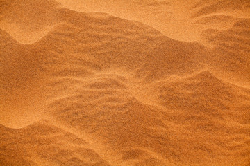 Desert orange sand dunes top view close up, yellow sand texture ornament, desert barchans...